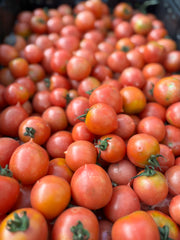 Load image into Gallery viewer, Close-up of a pile of red tomatoes with green stems.