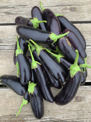 Load image into Gallery viewer, Bunch of dark purple eggplants with green stems on a wooden surface