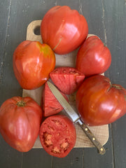Load image into Gallery viewer, Tomatoes on a cutting board with a knife
