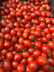 Load image into Gallery viewer, Pile of small red tomatoes with green stems
